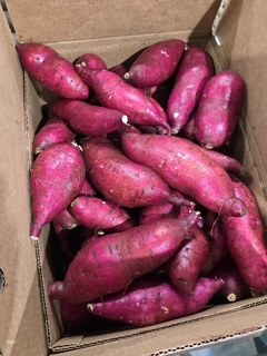 A box of Murasaki sweet potatoes with deep purple skin